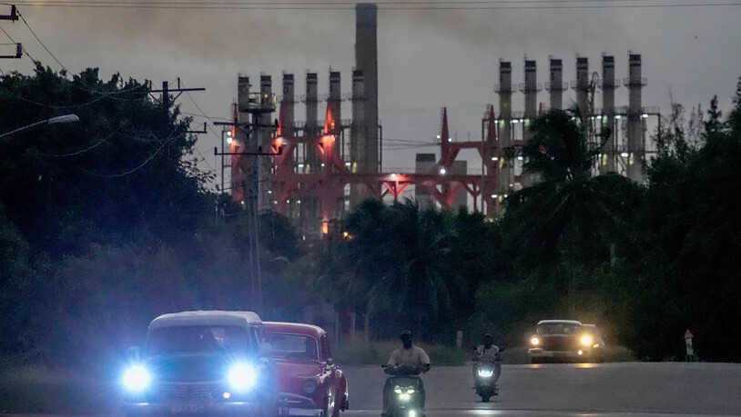 dpatopbilder - Menschen fahren an einem der Generatorschiffe im Hafen vorbei, die nach dem Stromausfall und Hurrikan «Milton» zusätzlichen Strom liefern. Foto: Ramon Espinosa/AP