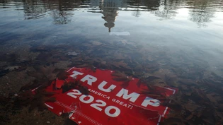 epa08925151 A 'Trump 2020' placard is submerged as the US Capitol Dome reflection is seen on the water of the US Capitol reflecting pool, in Washington, DC, USA, 07 January 2021, the morning after various groups of President Trump's supporters broke into USA CAPITOL RIOT AFTERMATH