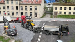 Ein Kommen und Gehen: Auf dem Umschlagplatz steht der erste Bagger (links), der am Montag vom Bauunternehmer angeliefert wurde, dahinter wird eine der beiden Spezialmaschinen der Armee für den Abtransport verladen. Ein Kommen und Gehen: Auf dem Umschlagplatz steht der erste Bagger (links), der am Montag vom Bauunternehmer angeliefert wurde, dahinter wird eine der beiden Spezialmaschinen der Armee für den Abtransport verladen.