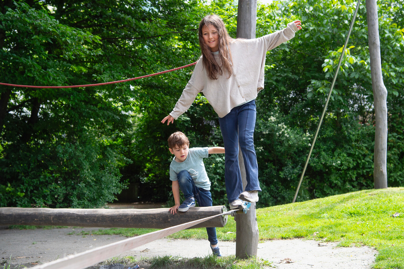 Balanceakt: Lou versucht sich an einer Slackline, während Dea den einfacheren Baumstamm ausprobiert.